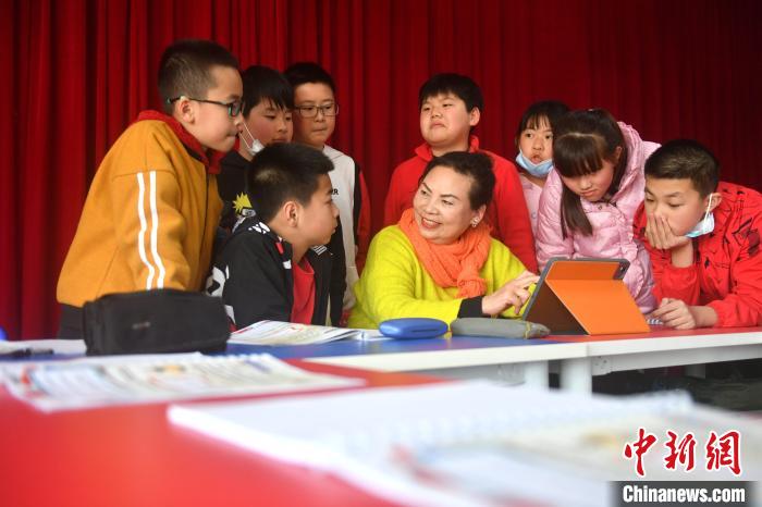 图为杨玉昭通过多媒体为孩子们授课。　吕明 摄